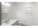 Clean and bright bathroom featuring white fixtures, a large mirror and natural lighting at 8205 Sw 100Th Lane Rd, Ocala, FL 34481