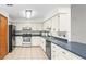 Functional kitchen featuring white cabinets, stainless steel appliances, and durable tile flooring at 8205 Sw 100Th Lane Rd, Ocala, FL 34481