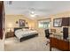 Cozy bedroom featuring a comfortable bed, a ceiling fan, a window, and a small desk area at 8554 Sw 63Rd Ct, Ocala, FL 34476