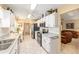 Open kitchen with stainless steel appliances, white cabinets, and views into the sunny living room at 8554 Sw 63Rd Ct, Ocala, FL 34476