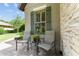 Charming front porch with chairs, a small table, and attractive greenery at 9158 Sw 65Th Loop, Ocala, FL 34481