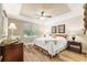 Comfortable bedroom featuring tray ceilings, updated ceiling fan and hardwood floors at 9158 Sw 65Th Loop, Ocala, FL 34481