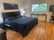 Bedroom featuring dark furniture, a large window, and modern decor at 9255 Sw 90Th Ct # B, Ocala, FL 34481
