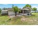 Backyard view shows a charming screened-in porch and patio with grass, a few trees, and a gravel area at 9420 Ne 12Th Ct, Ocala, FL 34479