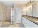 Bathroom features a shower, double sink vanity with granite countertop, and neutral color palette at 9420 Ne 12Th Ct, Ocala, FL 34479