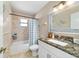 Bright bathroom with shower/tub combo, white vanity, and neutral color palette at 9420 Ne 12Th Ct, Ocala, FL 34479