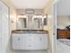 Bathroom features dual sinks, granite countertop, white cabinets, and modern fixtures at 9420 Ne 12Th Ct, Ocala, FL 34479