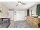 Neutral Bedroom features a ceiling fan, patterned rug, closet, and decoratively painted animal art above the changing table at 9420 Ne 12Th Ct, Ocala, FL 34479