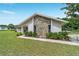 The side view shows a stylish home with a stone facade, complemented by lush green landscaping at 9420 Ne 12Th Ct, Ocala, FL 34479