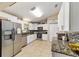 Modern kitchen with stainless steel appliances, granite countertops, and tiled backsplash at 9420 Ne 12Th Ct, Ocala, FL 34479