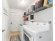 Bright laundry room with white washer and dryer, tile floor, and shelving unit for storage at 9420 Ne 12Th Ct, Ocala, FL 34479