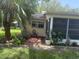 Exterior view of a home featuring screened lanai and mature palm trees at 9722 Sw 95Th Ct # C, Ocala, FL 34481