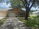 Charming home with garage, red trim, manicured lawn, and shade tree on a sunny day at 9722 Sw 95Th Ct # C, Ocala, FL 34481