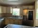Bright kitchen featuring stainless steel refrigerator, granite counters, and white cabinets at 9722 Sw 95Th Ct # C, Ocala, FL 34481