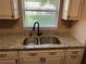 Kitchen sink area with window view, granite countertop, and white cabinets at 9722 Sw 95Th Ct # C, Ocala, FL 34481