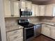 Well-lit kitchen with stainless steel appliances, granite countertops, and cream colored cabinets at 9722 Sw 95Th Ct # C, Ocala, FL 34481