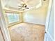 Spacious bedroom with tray ceiling, ceiling fan, and large window offering natural light at 10405 Sw 47Th Ave, Ocala, Florida, FL 34476