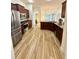Modern kitchen features stainless steel appliances, wood cabinets, granite countertops, and wood-look tile flooring at 10405 Sw 47Th Ave, Ocala, Florida, FL 34476