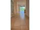 Hallway with tile flooring leading to a bright living area and sliding glass doors at 10584 Sw 91St Street Rd, Ocala, FL 34481