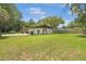 Expansive backyard with lush green grass, mature trees, and a fenced perimeter at 12178 Palmetto Way, Dunnellon, FL 34432
