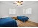 Inviting bedroom with two twin beds, wood-look flooring, and natural light from two windows at 12178 Palmetto Way, Dunnellon, FL 34432