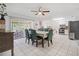 Bright dining area featuring white tile floors, modern lighting, and a view to the outdoor space at 12178 Palmetto Way, Dunnellon, FL 34432