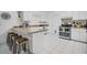 Clean kitchen featuring white cabinetry, updated appliances, and eat-in bar area at 12178 Palmetto Way, Dunnellon, FL 34432