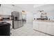 Open kitchen view with stainless steel refrigerator and breakfast bar, leading to dining area at 12178 Palmetto Way, Dunnellon, FL 34432