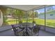 Screened lanai with outdoor seating, offering a relaxing view of the surrounding yard at 12178 Palmetto Way, Dunnellon, FL 34432