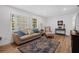 Bright living room featuring wood-look floors, ample natural light, and comfortable seating arrangement at 12178 Palmetto Way, Dunnellon, FL 34432