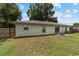 Backyard showcasing the house, grassy lawn, and partial fencing for added privacy at 1245 Nw 67Th Pl, Ocala, FL 34475