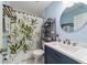 Bathroom with a modern vanity, round mirror, and a decorative shower curtain at 1245 Nw 67Th Pl, Ocala, FL 34475