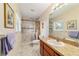 Bright bathroom with a marble-tiled shower, mosaic accents, and wood vanity at 1245 Nw 67Th Pl, Ocala, FL 34475