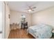 Bright bedroom with wood-look floors, a ceiling fan, and a window offering natural light at 1245 Nw 67Th Pl, Ocala, FL 34475