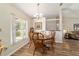 Dining room with wood table, chairs, chandelier, and natural light from a large window at 1245 Nw 67Th Pl, Ocala, FL 34475