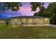 Charming single-story home with well-maintained lawn and front yard landscaping at dusk at 1245 Nw 67Th Pl, Ocala, FL 34475