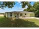 Charming one-story home with a well-manicured lawn, walkway, and light green exterior at 1245 Nw 67Th Pl, Ocala, FL 34475