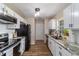 A well lit kitchen with granite countertops, stainless steel appliances, and white cabinets at 1245 Nw 67Th Pl, Ocala, FL 34475