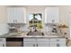 Bright kitchen with granite countertops, stainless steel appliances, white cabinets, and garden view at 1245 Nw 67Th Pl, Ocala, FL 34475