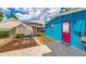 Backyard showcasing a shed and the stylish home exterior with a colorful door and patio area at 1404 Richmond Rd, Lakeland, FL 33801