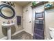 This bathroom features a pedestal sink, wood look floors, and a modern towel ladder at 1404 Richmond Rd, Lakeland, FL 33801