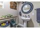 Bathroom featuring a pedestal sink, decorative mirror, and wood shelving unit at 1404 Richmond Rd, Lakeland, FL 33801