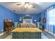 Comfortable bedroom featuring blue walls, light-colored flooring, and guitars on the wall at 1404 Richmond Rd, Lakeland, FL 33801