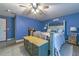 Comfortable bedroom featuring blue walls, light-colored flooring, and a ceiling fan at 1404 Richmond Rd, Lakeland, FL 33801