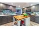 Open kitchen featuring gray cabinets, a wooden island, and modern appliances at 1404 Richmond Rd, Lakeland, FL 33801