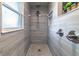 Tiled shower with pebble floor, rain shower head, and decorative nooks at 1404 Richmond Rd, Lakeland, FL 33801