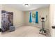 Bright bedroom with neutral walls, carpet flooring, window, and exercise equipment at 1553 Ne 161St Pl, Citra, FL 32113