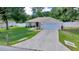 Inviting single-story home featuring a well-maintained lawn, a driveway, and a two-car garage at 1553 Ne 161St Pl, Citra, FL 32113