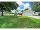 Exterior featuring a two-car garage, manicured lawn, and mature shade trees at 1553 Ne 161St Pl, Citra, FL 32113