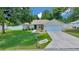 Inviting single-story home featuring a well-maintained lawn, a driveway, and a two-car garage at 1553 Ne 161St Pl, Citra, FL 32113